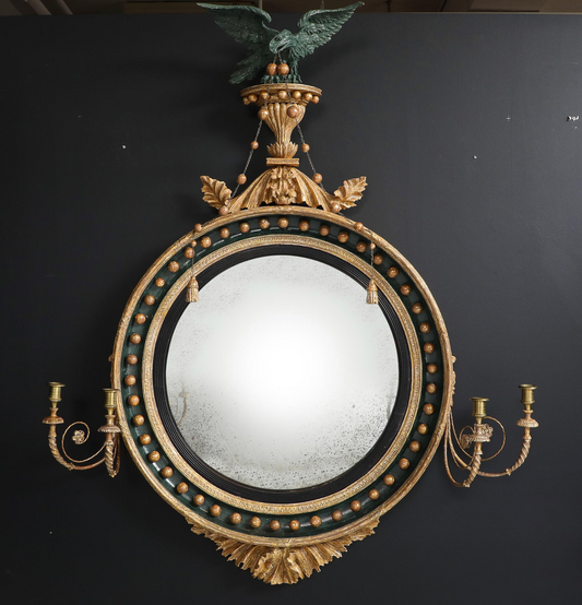 Carved, gilded and painted convex mirror/girandole.